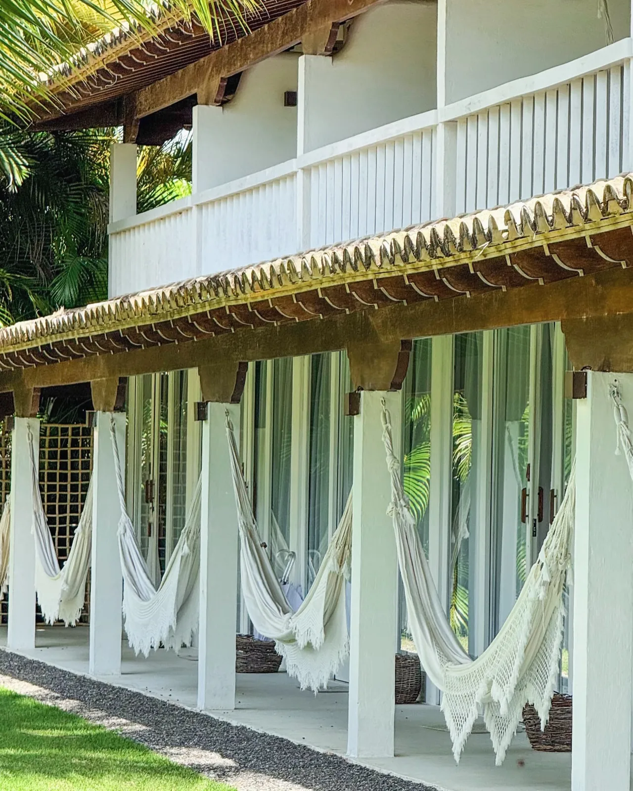 Fileira de redes na varanda do Brisas, entre o verde do Outeiro